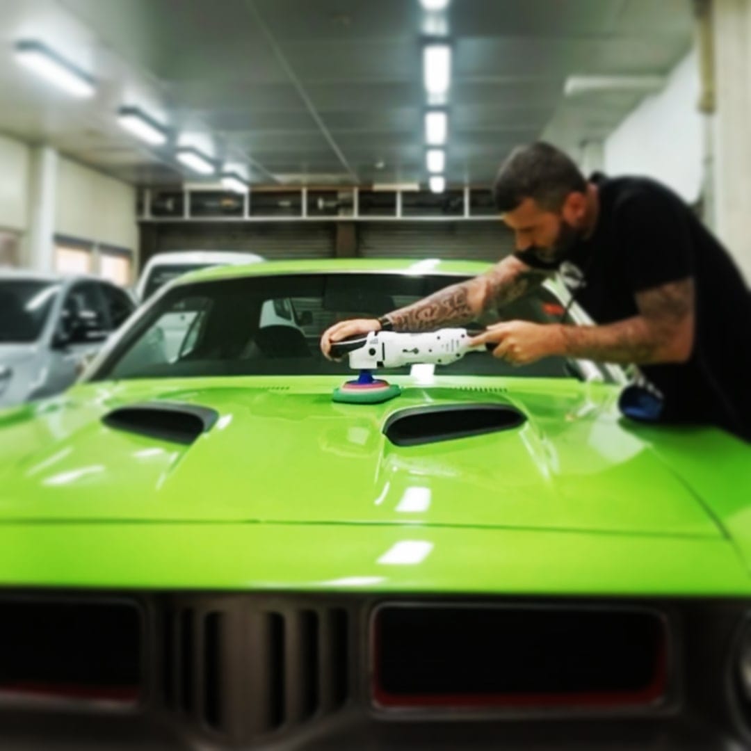 Jonathan puliendo un deportivo clásico verde