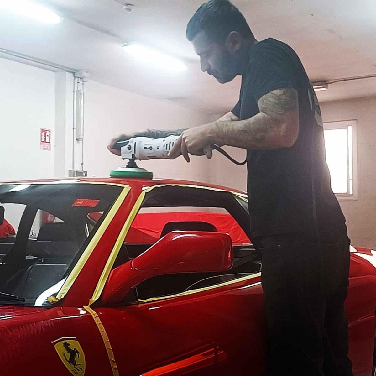 Jonathan puliendo un deportivo clásico rojo