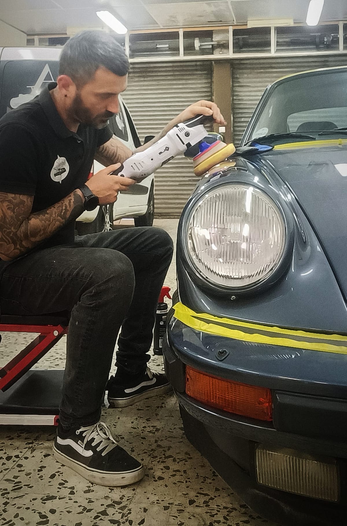 Jonathan puliendo el faro de un Porsche clásico